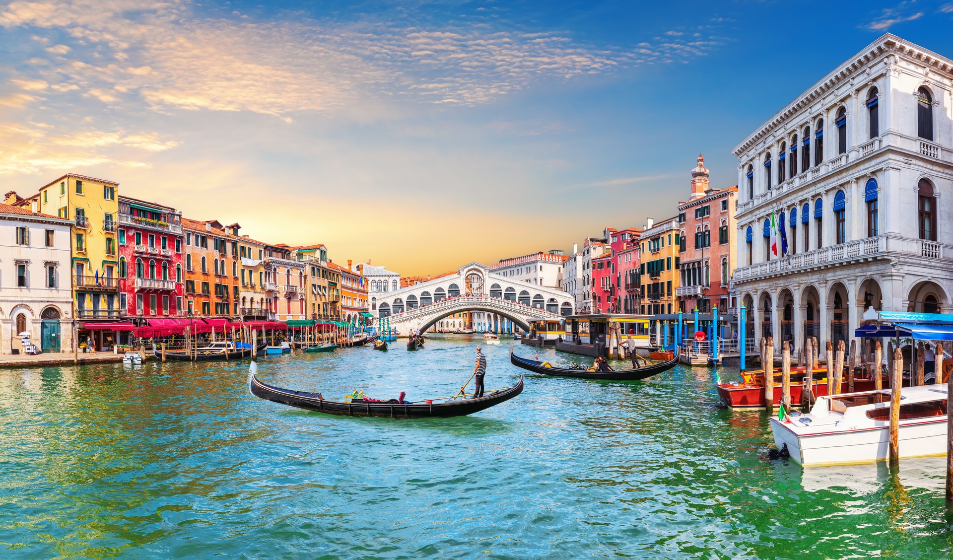 Venice Grand Canal, view of the Rialto Bridge and gondoliers, Italy